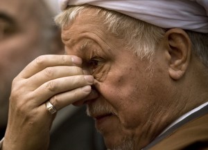 The head of Iran's Assembly of Experts, Rafsanjani, listens as he is introduced to speak at a conference in Tehran